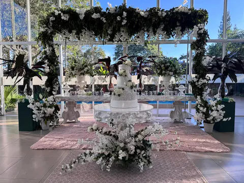 Mesa principal de una boda con pórtico de follaje