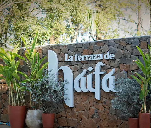 El cartel de La Terraza de Haifa sobre el muro de piedra