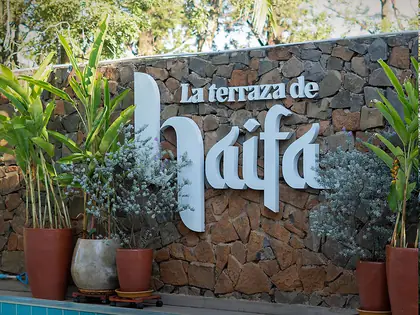El muro de piedra con las letras de La Terraza de Haifa