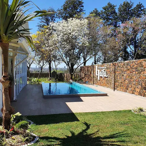 La piscina y el muro de piedra, con edificios de Ciudad del Este al fondo