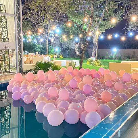 Globos rosados flotando en la piscina de noche