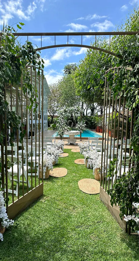 El jardín visto a través de un portón con enredaderas