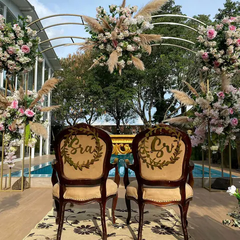 Las sillas de los novios bajo un arco de flores